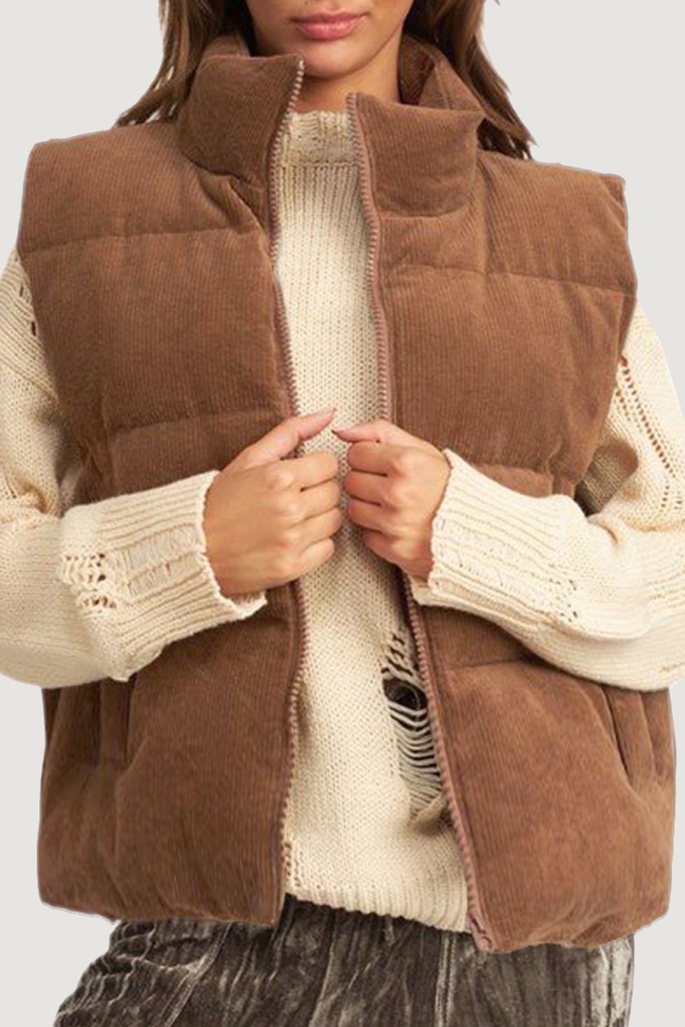 Woman wearing coffee-colored corduroy puffer vest with cream sweater and zip closure.