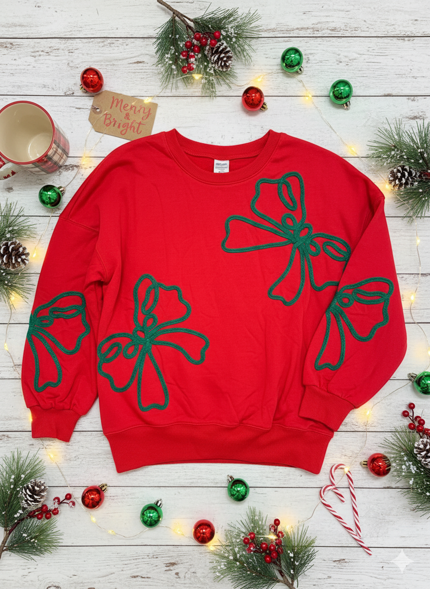 a red corded oversized Christmas sweatshirt with embroidered green bow patterns — festive holiday pullover from The Pink Doxie.