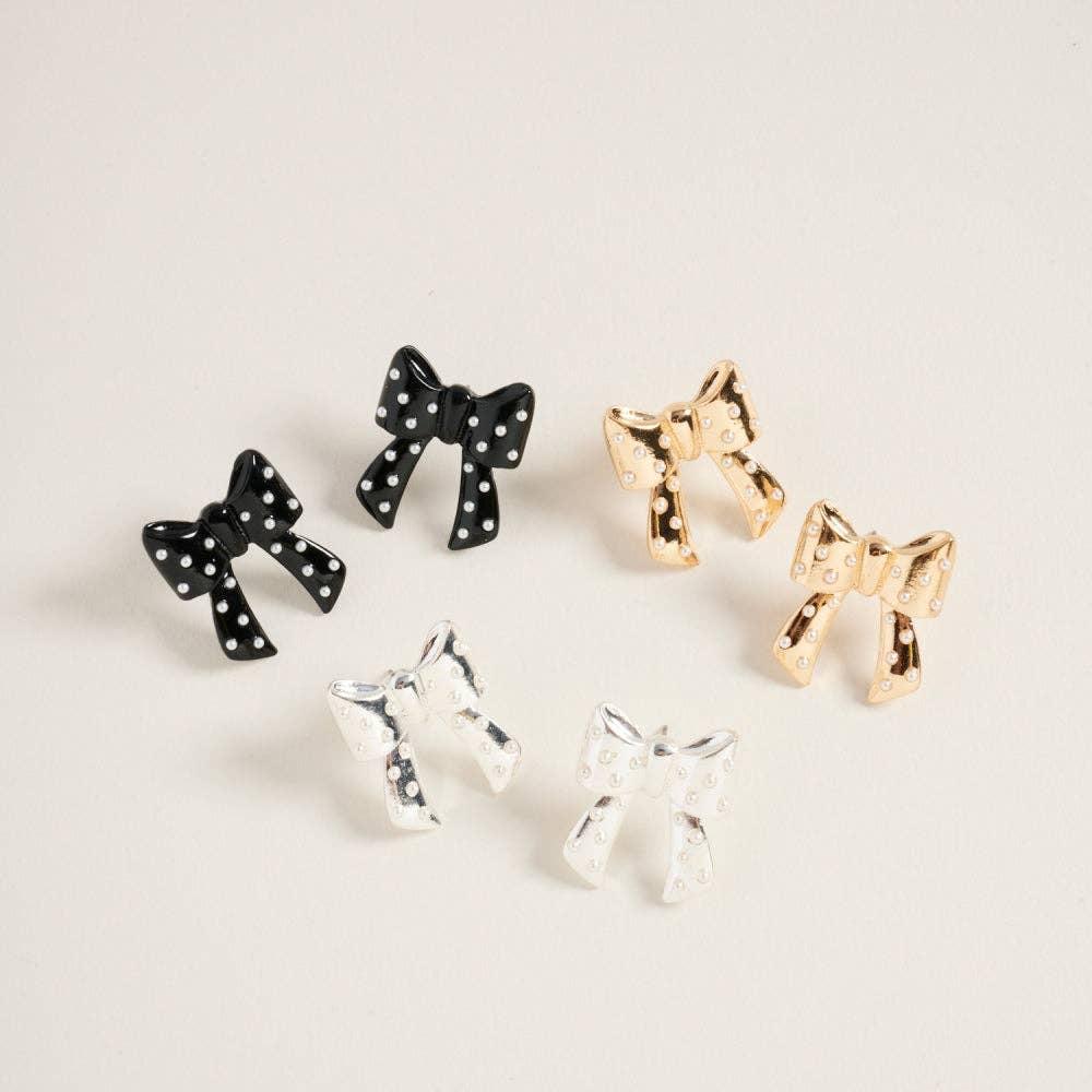 Black polka dot bow earrings with pearl post centers displayed on a neutral background.