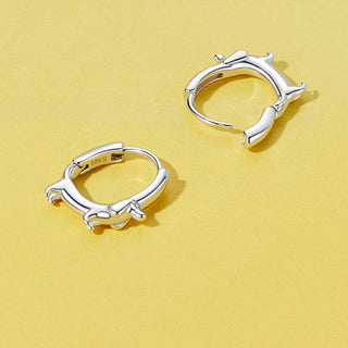 Sterling silver hoop earrings with a dachshund design on a yellow background.