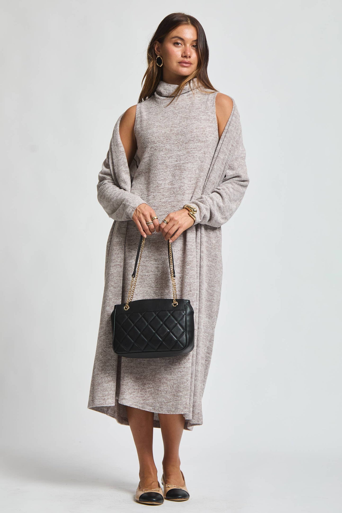 Woman wearing a brushed cashmere hacci cowl neck dress with matching open-front cardigan in a heathered neutral tone.