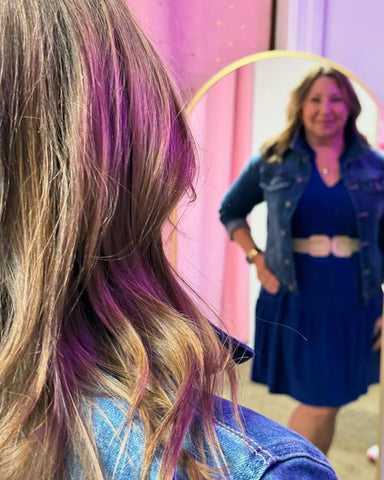 Customer seeing herself in mirror trying on boutique outfit