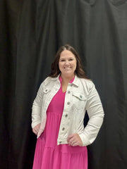 Woman in hot pink dress and white jacket modeling boutique style for all sizes