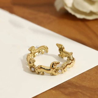 Open ring with gold-plated dachshund motifs and pearl accents on a textured shank.