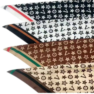 Four silky square bandana scarves with monogram border prints in black, white, brown, and beige.