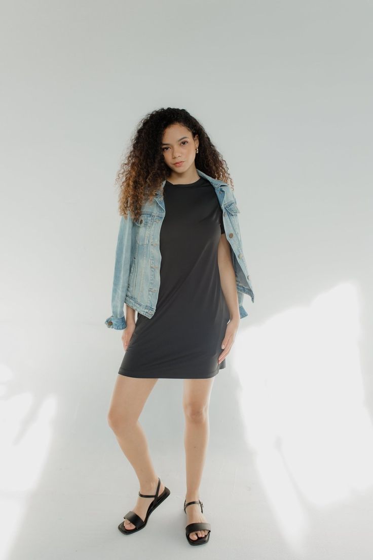 Woman wearing a black tee shirt mini dress with a relaxed fit, styled casually with sandals, from The Pink Doxie Boutique.
