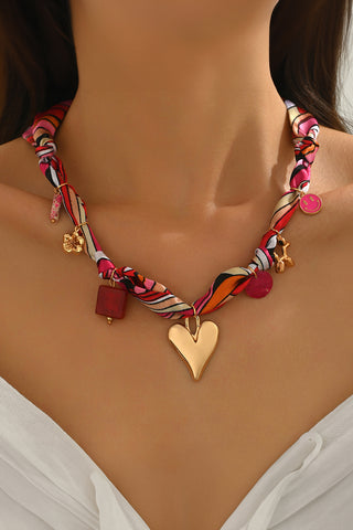 Strawberry pink printed knot scarf necklace with gold heart charm and multi detail accents, stylish Valentine accessory from The Pink Doxie Boutique.