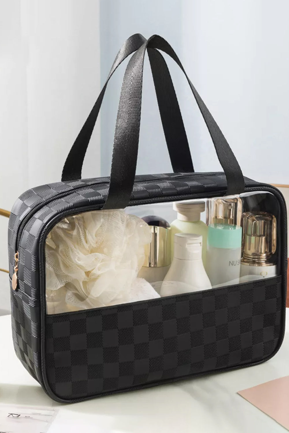 Black checkered clear PVC cosmetic bag with handles, filled with skincare and beauty products, stylish and travel-friendly from The Pink Doxie Boutique.