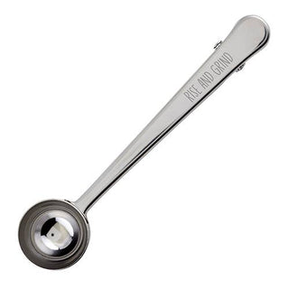Stainless steel coffee scoop and clip engraved with “Rise and Grind” — one-tablespoon coffee accessory from The Pink Doxie Boutique.