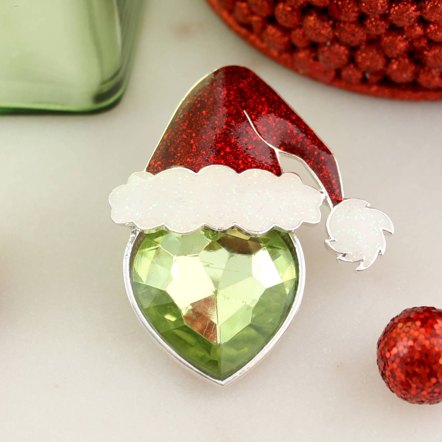 Green crystal heart brooch with glittery red Santa hat — festive Christmas pin or pendant from The Pink Doxie.
