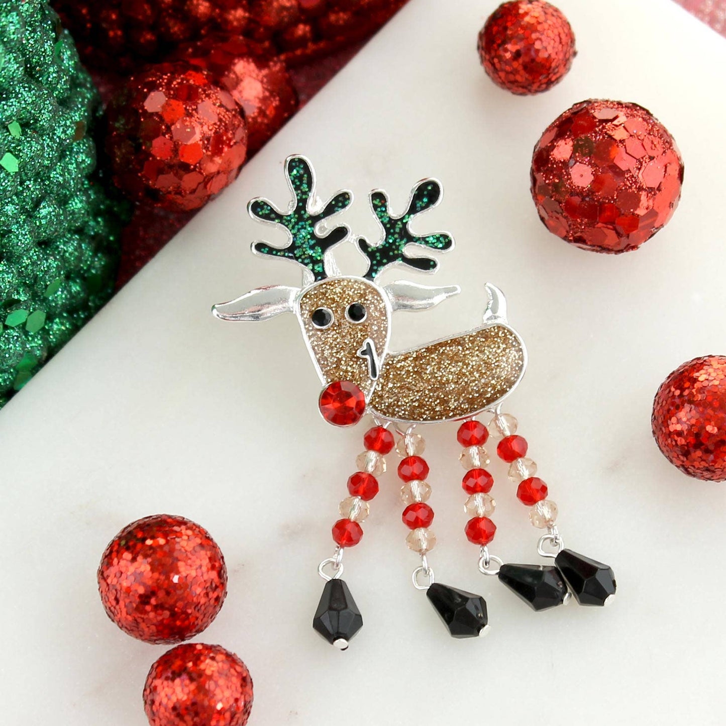 Silver-plated reindeer Christmas pin pendant with glitter enamel and dangling crystal bead legs — festive holiday jewelry from The Pink Doxie.