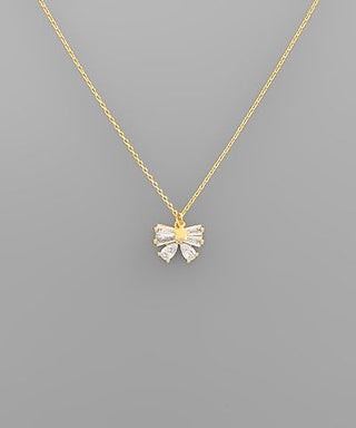 Gold-dipped necklace with baguette crystal ribbon bow pendant, photographed for The Pink Doxie Boutique.