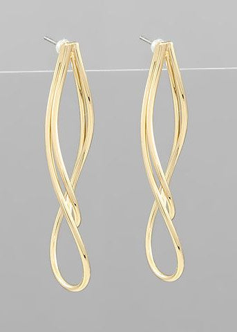 Gold-toned twisted drop earrings with a sleek tornado-inspired design displayed on a gray background from The Pink Doxie Boutique.