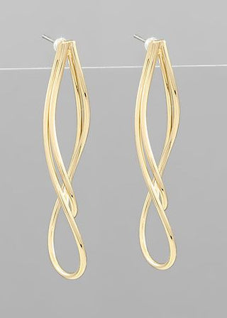 Gold-toned twisted drop earrings with a sleek tornado-inspired design displayed on a gray background from The Pink Doxie Boutique.