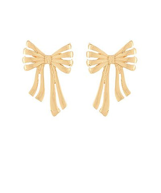 Gold-tone metal bow statement earrings with flowing ribbon detail displayed on a white background from The Pink Doxie Boutique.