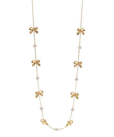 Long gold chain necklace with bow details and faux pearl accents, photographed for The Pink Doxie Boutique.