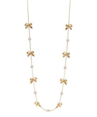 Long gold chain necklace with bow details and faux pearl accents, photographed for The Pink Doxie Boutique.
