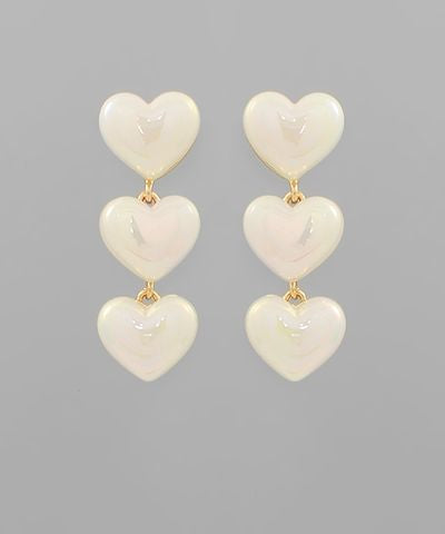Cream acrylic heart drop earrings featuring three glossy hearts in a cascading design on a neutral background from The Pink Doxie Boutique.