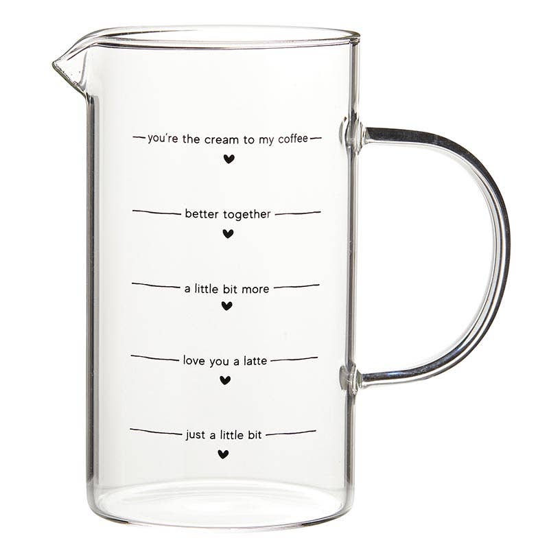 Clear glass creamer pitcher with handle and black printed coffee-themed sayings — kitchen coffee bar accessory from The Pink Doxie Boutique.