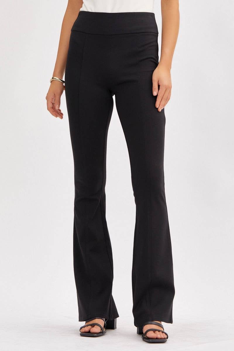 Woman wearing high waisted black flare pants with tummy control fit from The Pink Doxie Boutique.