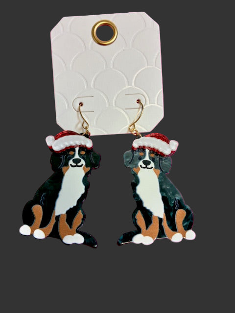 Bernese Mountain Dog earrings with Santa hats on a pink background