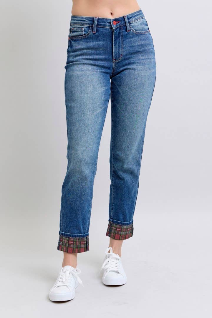 Model wearing medium-wash Judy Blue boyfriend jeans with plaid cuff detail, styled with white sneakers.