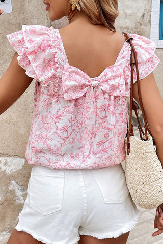 Pink floral blouse with ruffled sleeves and bow-back detail, feminine summer top styled with white shorts from The Pink Doxie Boutique.