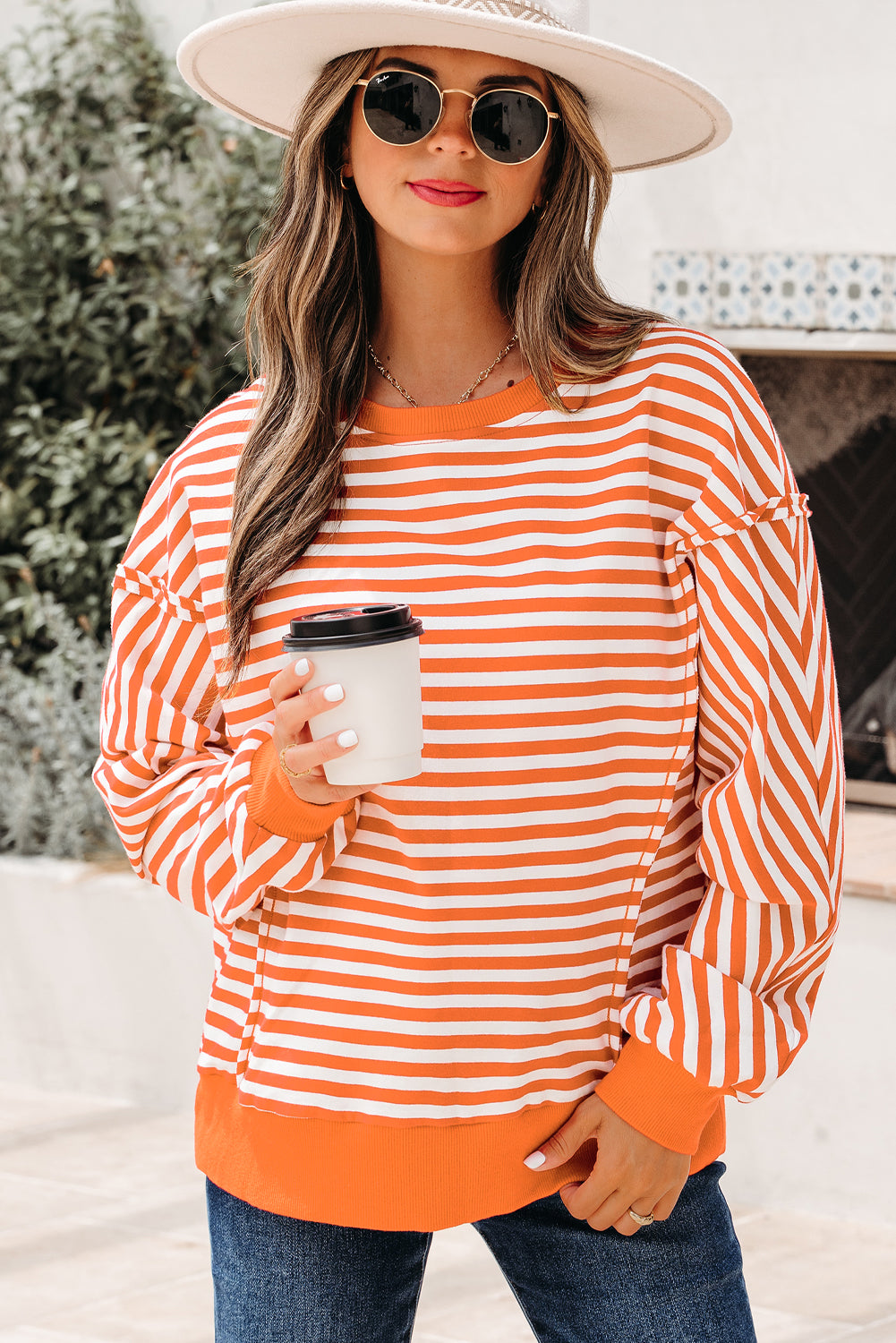 Orange and white striped drop shoulder pullover with exposed seams, styled casually for Tennessee game day at The Pink Doxie Boutique.