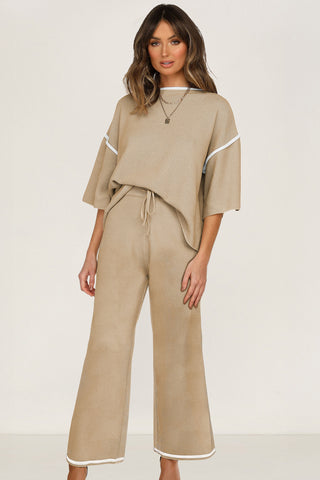 Woman wearing a camel knit sweater set with contrast trim, featuring a half sleeve top and drawstring pants.