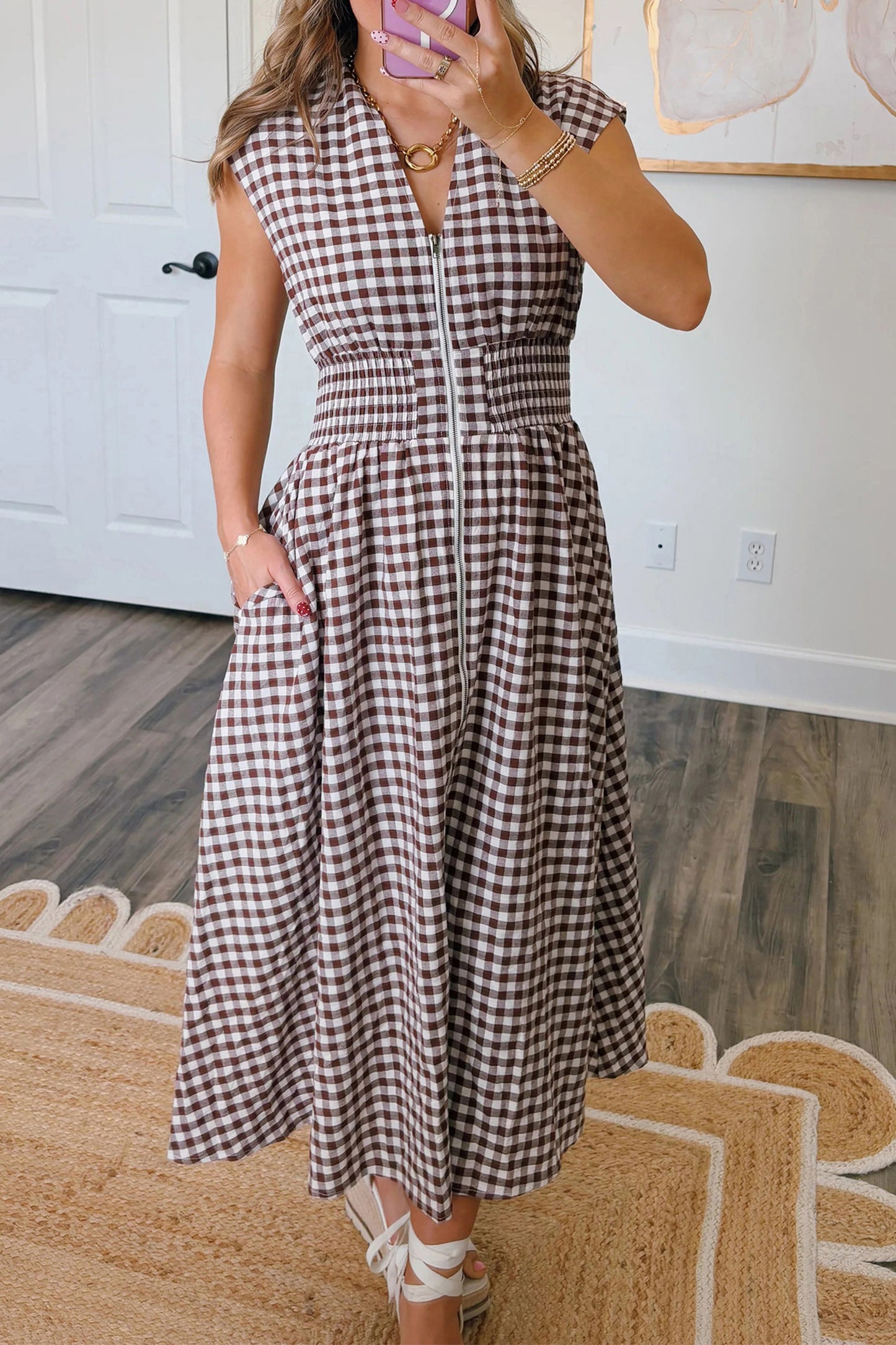 Woman wearing a coffee plaid sleeveless maxi dress with full zipper and cinched waist