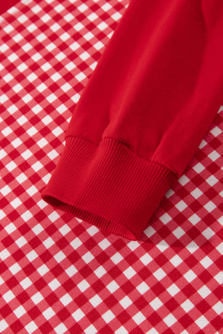 A woman wearing a two-piece matching set with a red and white gingham patchwork pullover with solid red sleeves and coordinating wide-leg pants with a drawstring waist and side pockets.