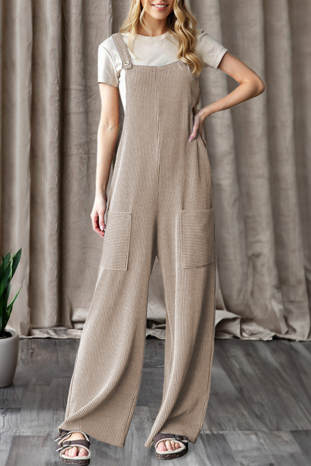 Woman wearing ribbed knit wide leg overalls with patch pockets layered over a short sleeve top, styled casually for everyday wear from The Pink Doxie Boutique.