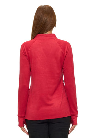 A woman wearing a cherry red long-sleeve pullover top with a v-neckline, raglan sleeves, cuffed wrists, and a front kangaroo pocket, styled with black pants.