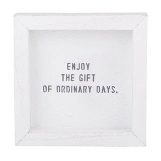 White wooden sign with the phrase “Enjoy the gift of ordinary days” — inspirational home décor piece from The Pink Doxie Boutique.