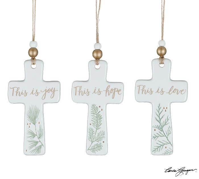 Three hand-painted ceramic cross ornaments with greenery and gold lettering reading This Is Joy, This Is Hope, and This Is Love — Christian Christmas ornaments from The Pink Doxie.
