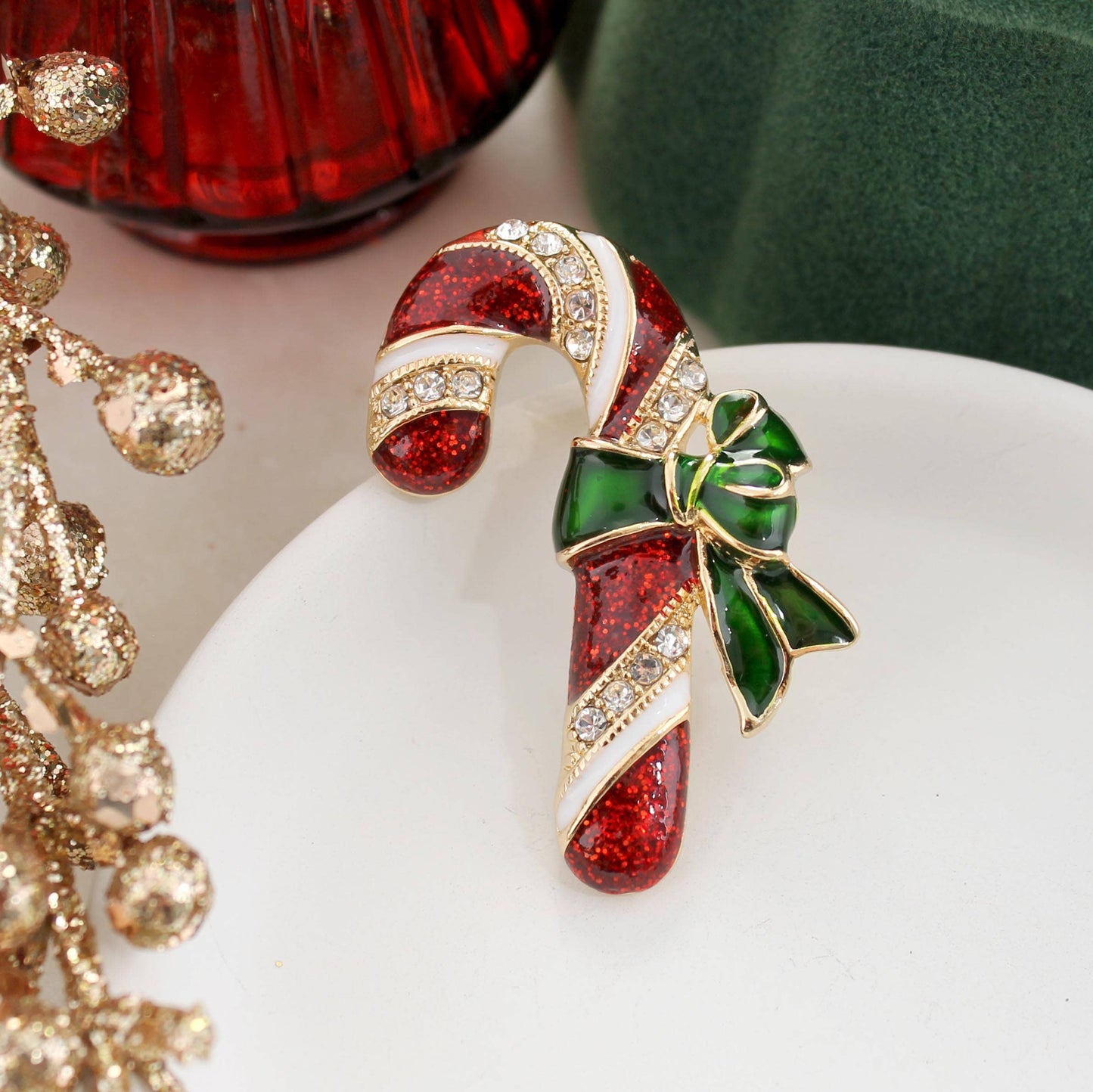 Gold-tone vintage candy cane pin pendant with glitter red and white enamel and green bow accent — Christmas jewelry from The Pink Doxie.