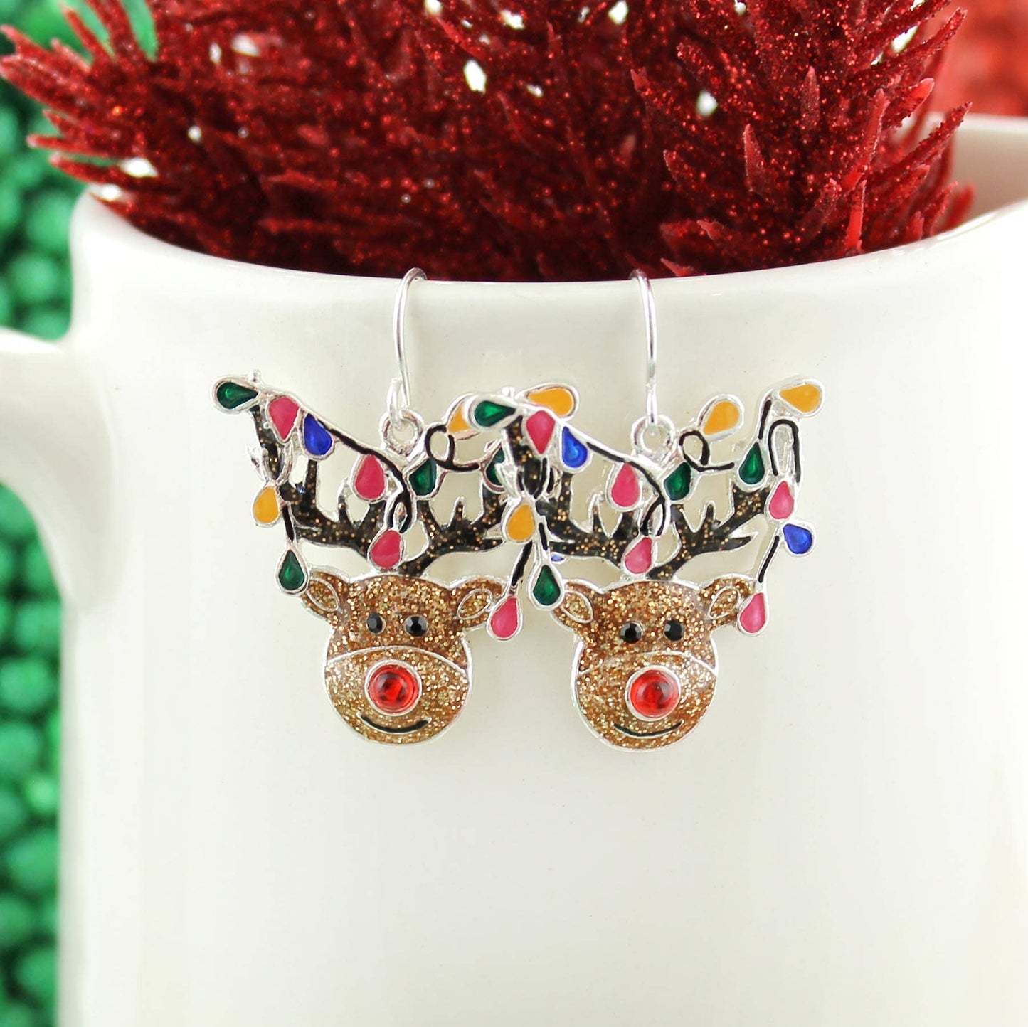 Silver-plated whimsical reindeer Christmas earrings with glitter enamel and colorful holiday lights — festive jewelry from The Pink Doxie.