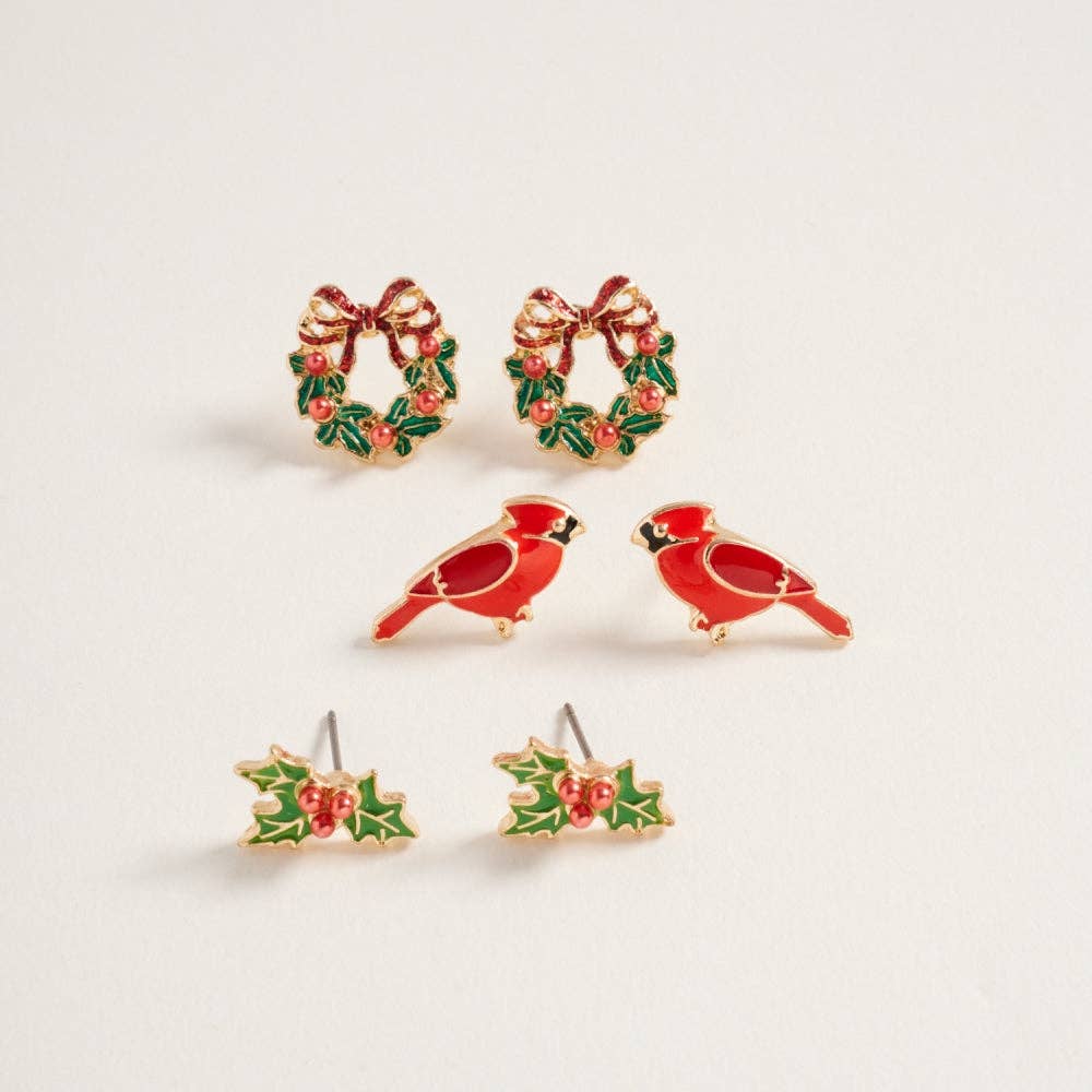 Three pairs of Christmas-themed stud earrings: wreaths, red cardinals, and holly leaves displayed on a neutral background.