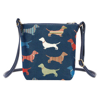 Sling bag with a dachshund tapestry design in multicolor on navy fabric, featuring an adjustable strap.