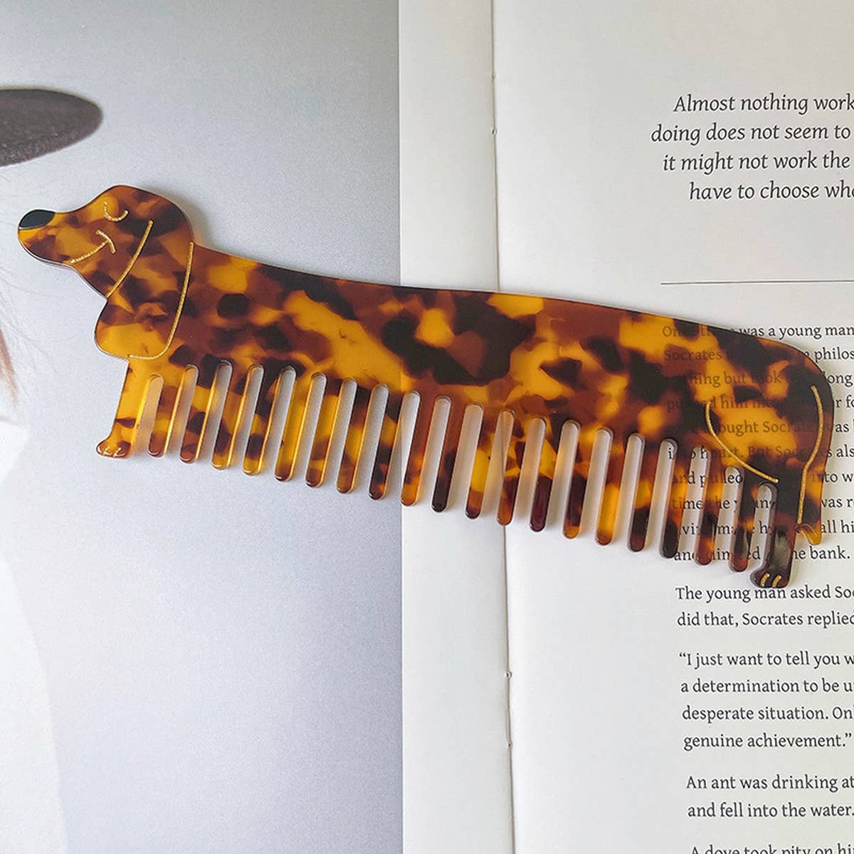 Tortoiseshell comb shaped like a dachshund on an open book