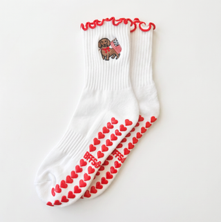 White socks with red heart patterns and a small dog illustration on a white background