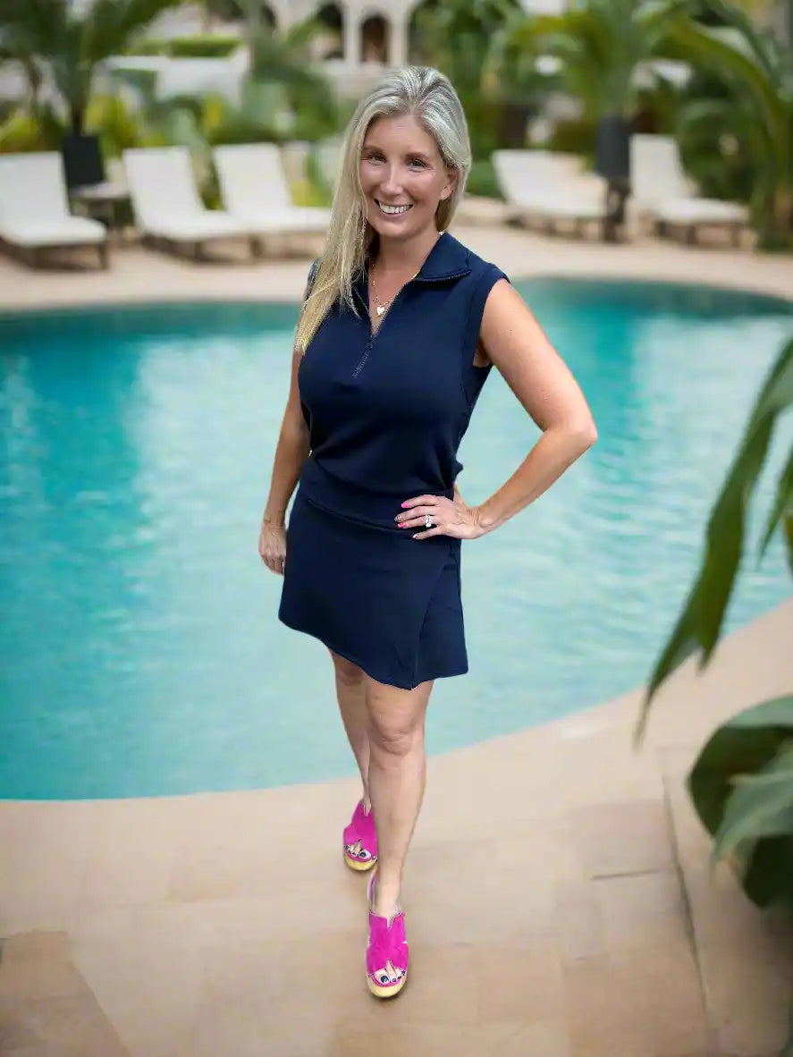 Woman in navy dress and pink shoes.